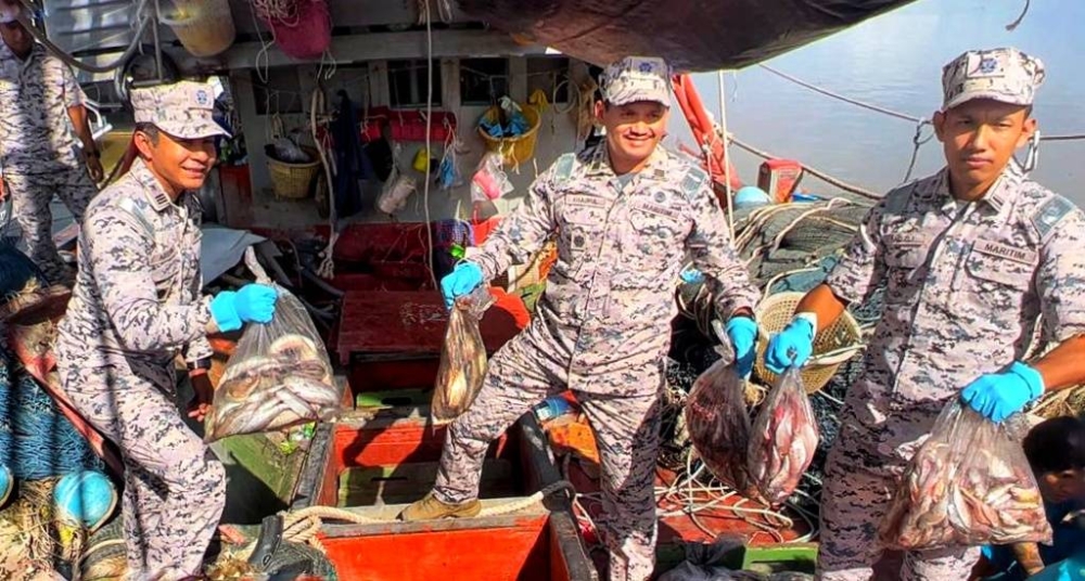 Mohd Khairulanuar (tengah) menunjukkan antara hasil rampasan dari dua buah bot nelayan Vietnam yang ditahan menceroboh perairan negara pada malam Ahad. 