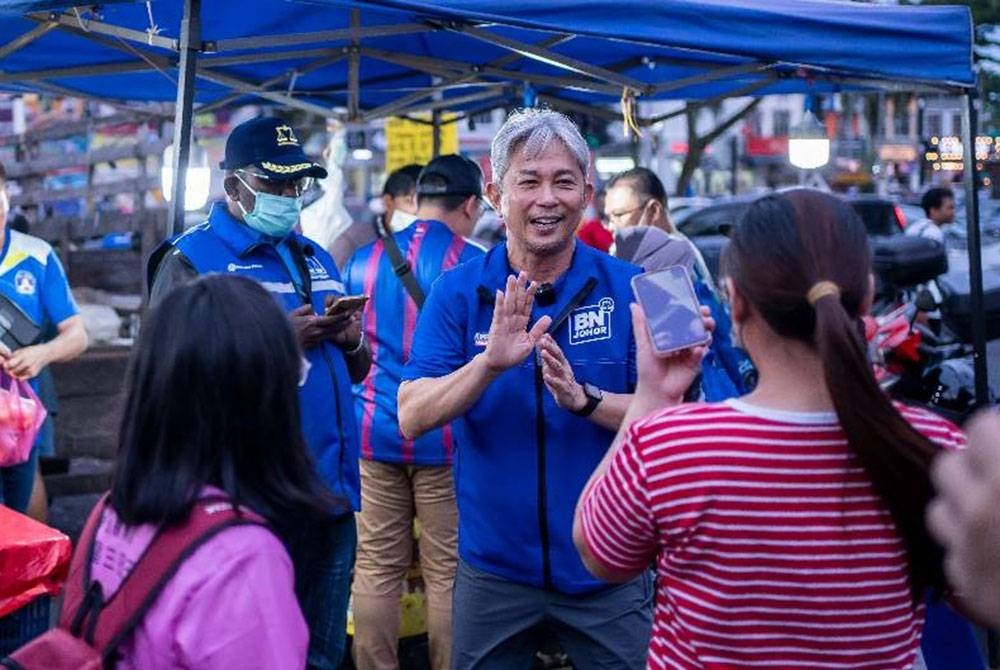 Jason (tengah) berkata sesuatu kepada pengunjung ketika berkempen di Pasar Malam Nusa Perintis, baru-baru ini.