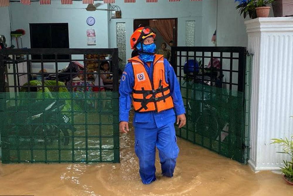 Anggota Angkatan Pertahanan Awam (APM) meninjau keadaan banjir di Jalan Bunga Dahlia 8, Senai, Johor Bahru, pada Rabu.