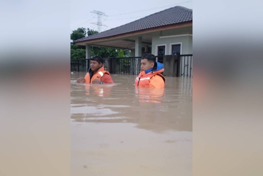 Dua anggota APM membantu dalam operasi memindah dan menyelamat mangsa banjir di negeri ini pada Khamis.