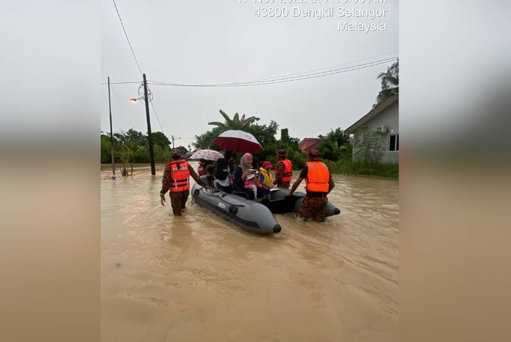 Penduduk dipindahkan dengan menggunakan bot ketika anggota BBP Dengkil menjalankan operasi banjir di Kampung Cemperai, Dengkil Khamis. - Foto Bomba Selangor