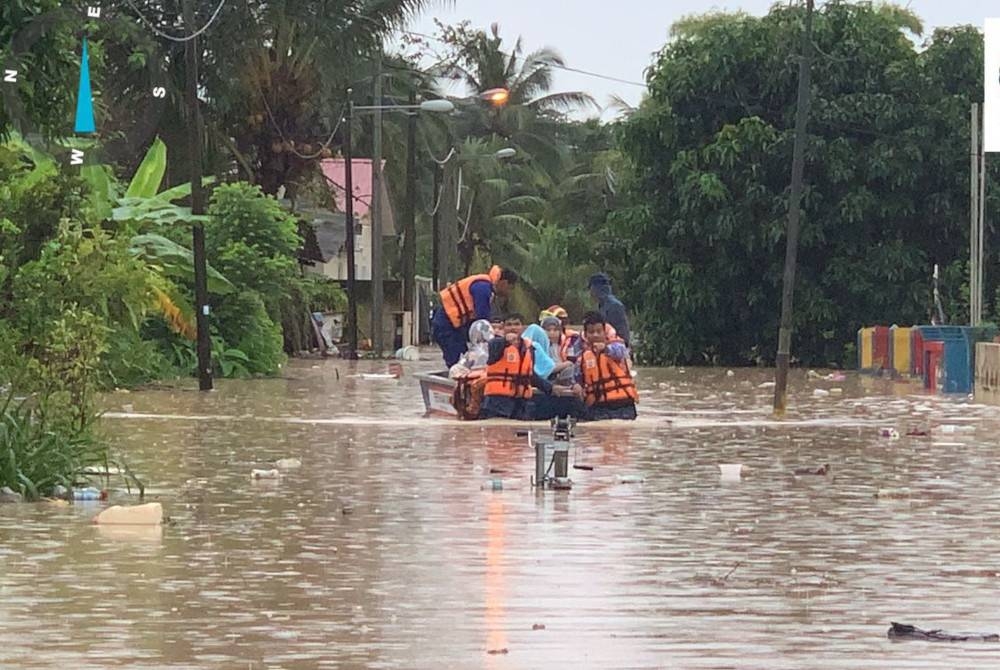 Anggota Angkatan Pertahanan Awam Malaysia (APM) membantu operasi dan menyelamat mangsa yang dilanda banjir pada Khamis.