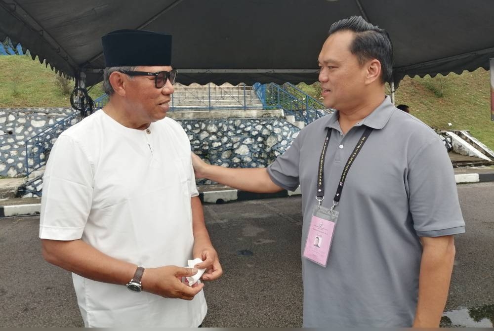 Wun Hoong (kanan) beramah mesra dengan calon PN, Abdul Rashid ketika ditemui pada proses undi awal yang berlangsung di IPD Gombak, Selasa lalu.