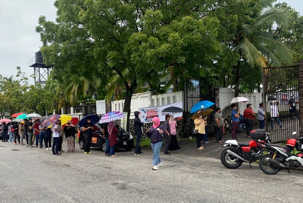 Antara pengundi yang beratur dalam keadaan hujan renyai sementara menunggu giliran masuk ke pusat mengundi di Dewan Melur, Seksyen 7, di sini, sekitar jam 8 pagi, pada Sabtu.