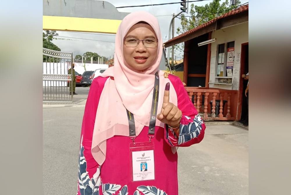 Calon BN Parlimen Ketereh, Marzuani Ardila Ariffin menunjukkan calitan jarinya selepas selesai membuang undi di SMK Ketereh kira-kira jam 9.25 pagi pada Sabtu.