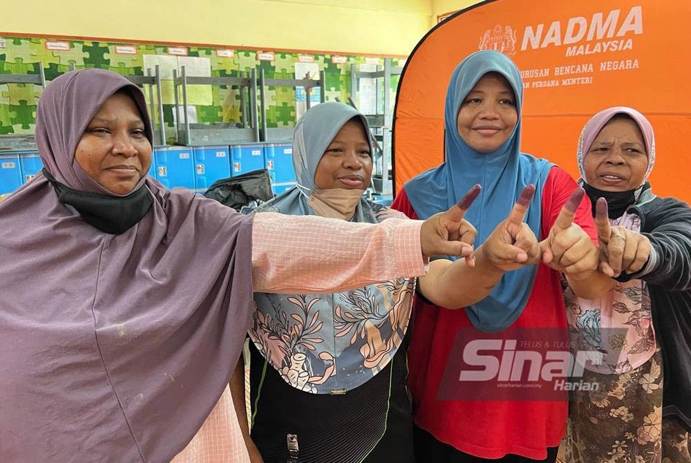 (Dari kiri) Ainon Ibrahim, 45; Faridah Ibrahim, 42; Fatimah dan Zaharah Ibrahim, 62, menunjukkan jari tanda selesai mengundi bagi Parlimen Sepang.