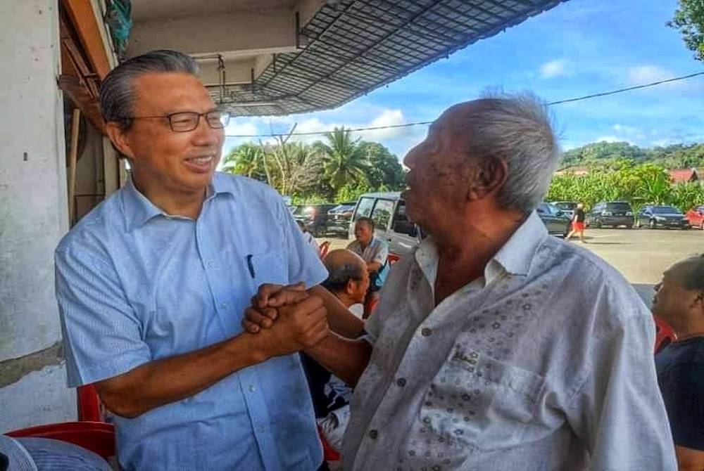 Tiong Lai (kiri) ketika menyantuni orang ramai semasa kempen PRU15. - Foto FB Liow Tiong Lai