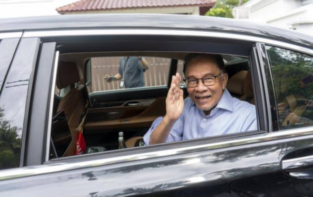 Anwar melambai kepada petugas media ketika menaiki sebuah kereta keluar dari kediamannya di Cheras, Kuala Lumpur pagi tadi.