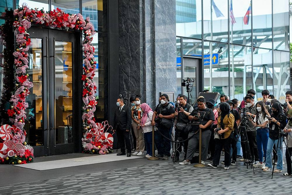 Petugas media membuat liputan di hadapan pintu masuk Hotel St Regis pada Rabu.- Foto Bernama.