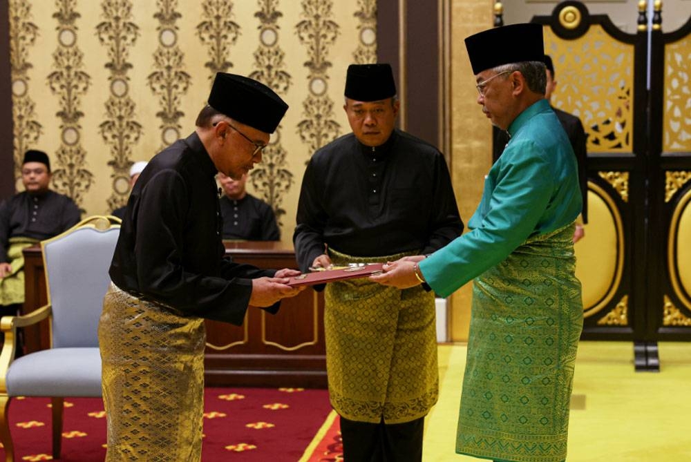 Al-Sultan Abdullah berkenan menyampaikan Surat Cara Pelantikan dan Mengangkat Sumpah Jawatan dan Setia serta Sumpah Simpan Rahsia kepada Anwar pada Istiadat Pengurniaan sebagai Perdana Menteri ke-10 di Istana Negara. - Foto Bernama