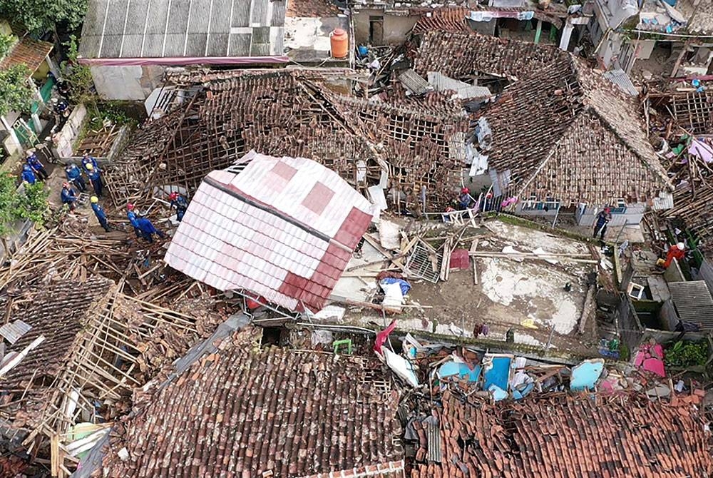 Pandangan dari udara menyaksikan anggota penyelamat berusia menggali rumah yang runtuh akibat gempa bumi di Cugenang, Cianjur, Jawa Barat. - AFP