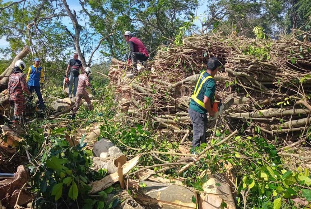 Anggota bomba dan MPKS membersihkan lokasi runtuhan tanah itu di Bukit Malawati di sini pada Jumaat.