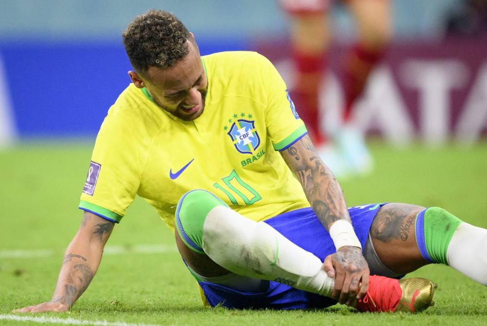 Neymar memegang buku lali kanannya semasa perlawanan bola sepak Piala Dunia FIFA 2022 kumpulan G antara Brazil dan Serbia di Stadium Lusail di Lusail, Qatar pada Khamis. - Foto EPA