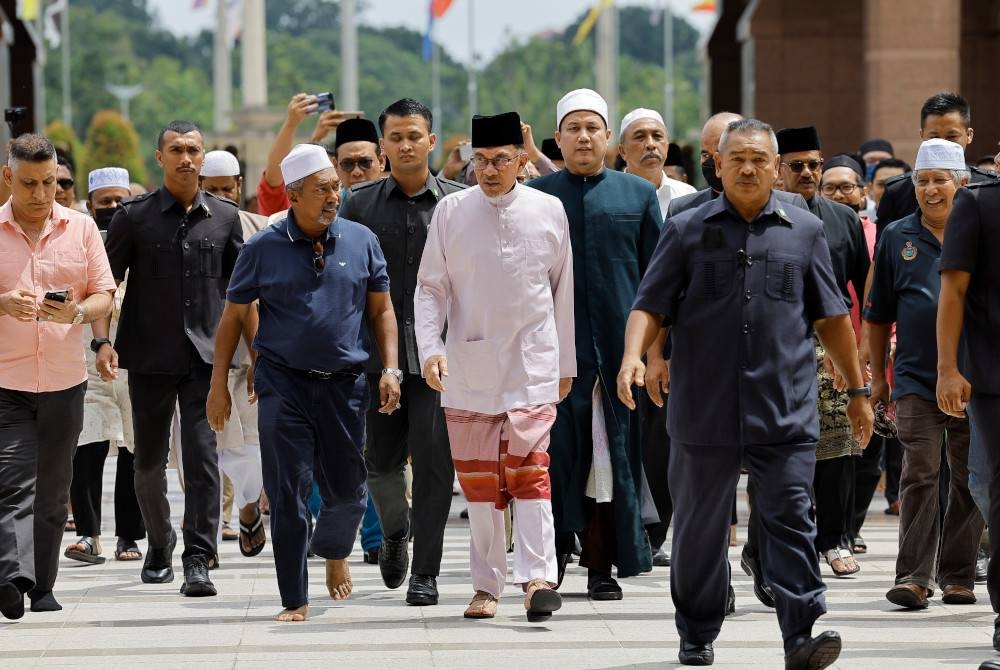 Anwar Ibrahim (tengah) hadir ke Masjid Putra untuk menunaikan solat Jumaat. - Foto Bernama