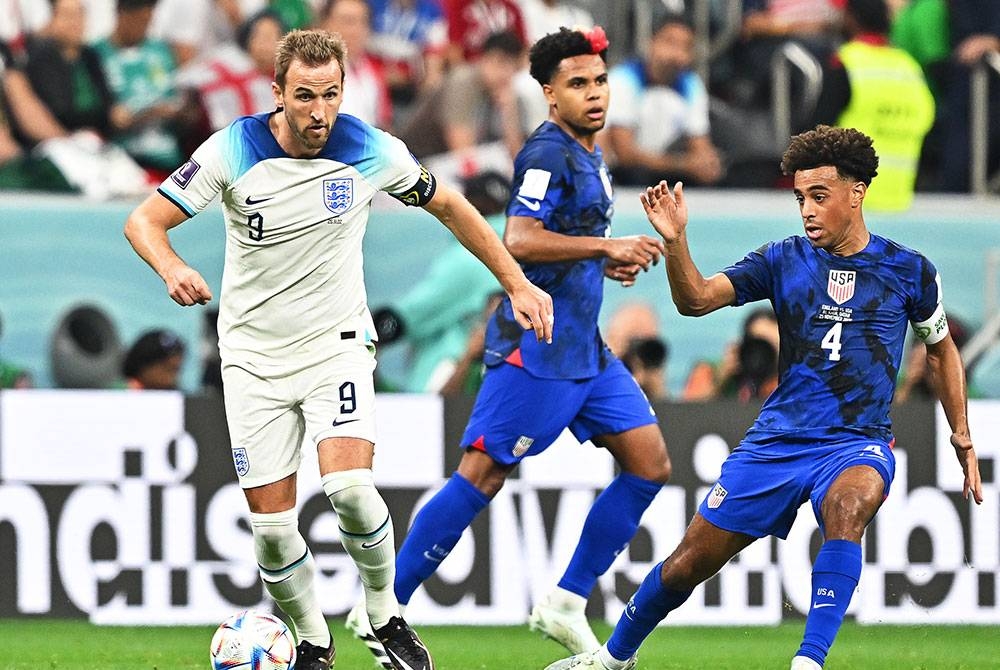 Kane (kiri) ketika diasak pemain AS semasa perlawanan Kumpulan B Piala Dunia Qatar 2022 di Stadium Al Bayt, Al Khor. - Foto EPA