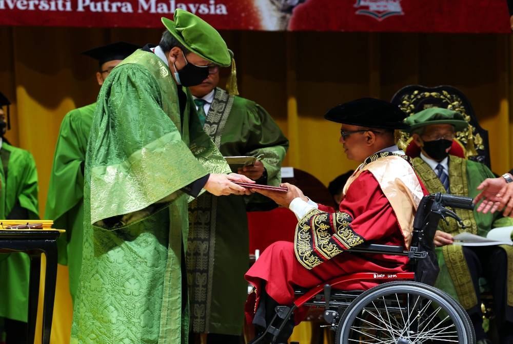 Sultan Sharafuddin (kiri) berkenan menyampaikan Ijazah Doktor Falsafalah (PhD) Bahasa Melayu kepada Arul Das Arumugam yang merupakan OKU pada Istiadat Pembukaan Konvokesyen Universiti Putra Malaysia (UPM) ke-46 sidang dua di UPM. - Foto Bernama