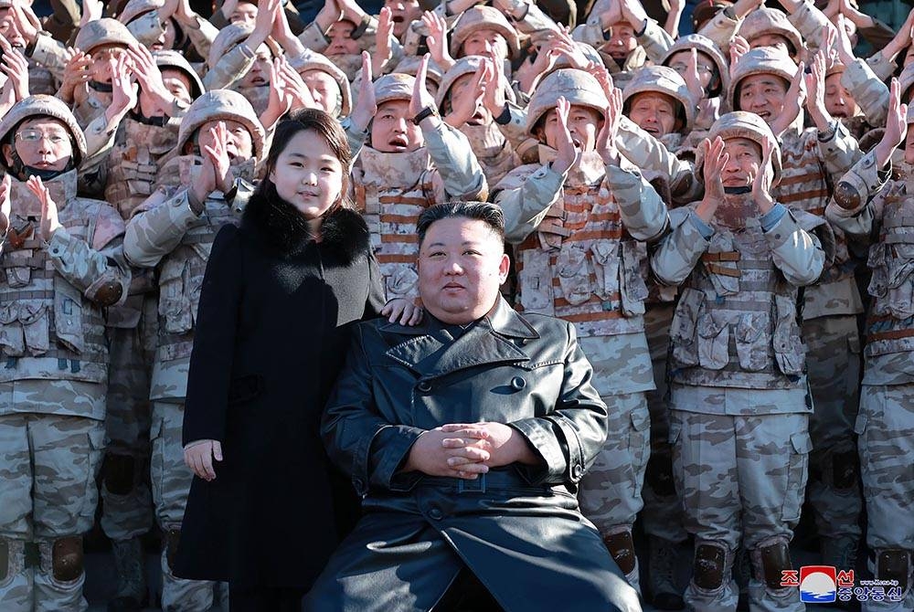 Kim Jong-un (kanan) dan anak perempuannya (kiri) bergambar dengan anggota tentera yang menyumbang kepada pelancaran peluru berpandu di Korea Utara. - AFP