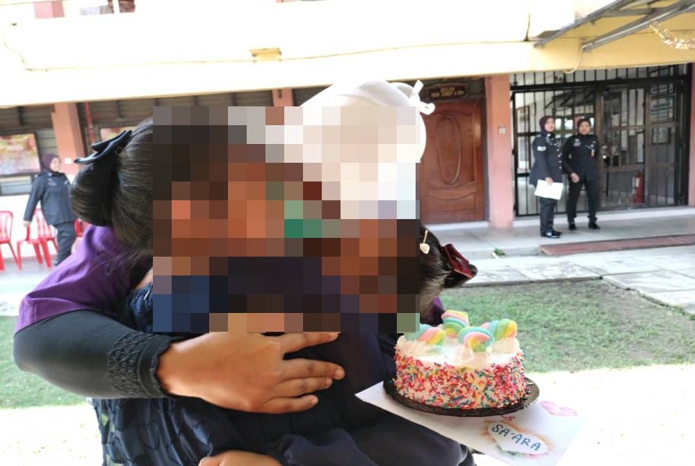 Kamariah memeluk dua anak perempuannya semasa ditemukan dalam program Jalinan Kasih di Penjara Simpang Renggam, Kluang, pada Ahad.