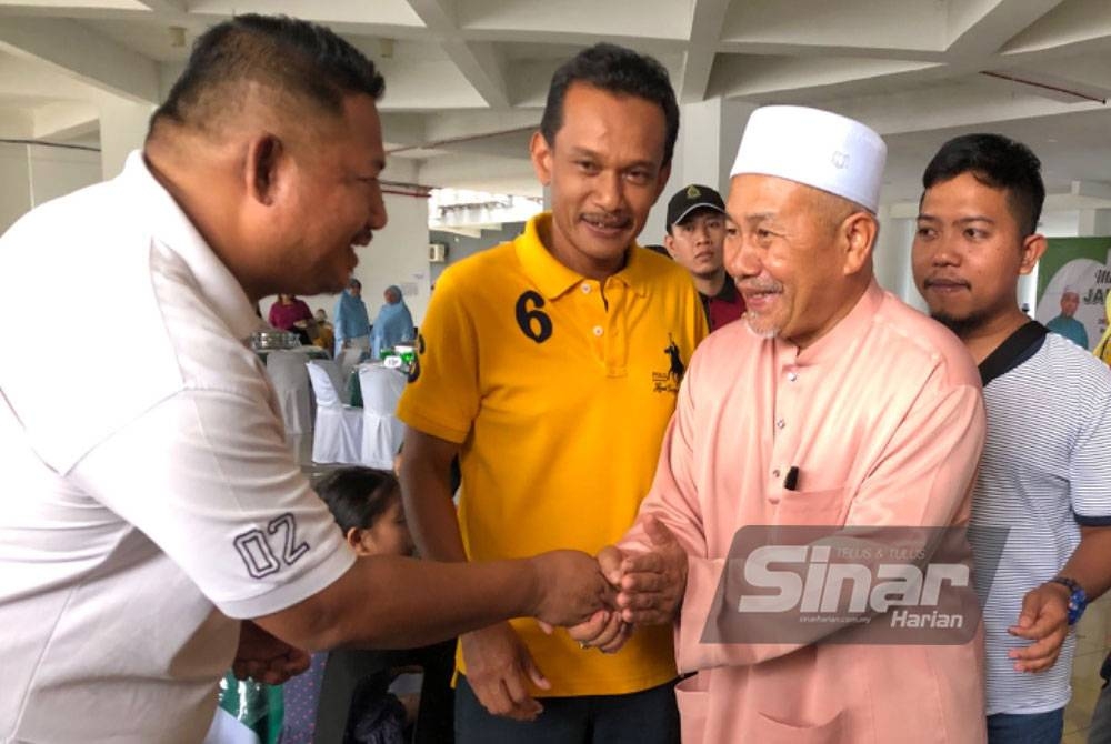 Tuan Ibrahim (dua dari kanan) bersalaman dengan tetamu yang hadir pada Jamuan Kesyukuran di Pasir Tumboh, Kota Bharu pada Isnin.