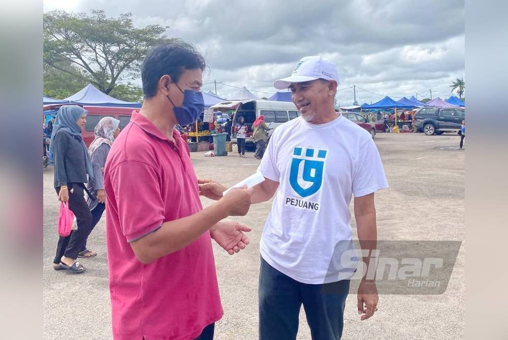 Osman (kanan) beramah mesra bersama rakyat Rompin di pasar.