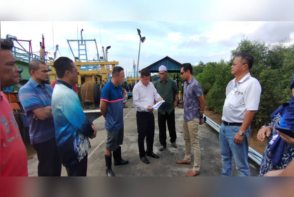 Boon Guan (empat dari kiri) bersama Chon Siang (empat dari kanan) dan Faizal (dua dari kanan) pada pertemuan berhubung isu bekalan diesel bersubsidi di Jeti LKIM, Kemunting pada Khamis.