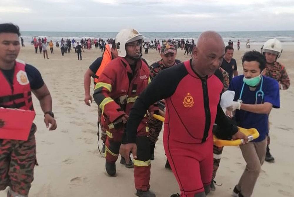 Anggota bomba mengusung mayat kanak-kanak lelaki berusia empat tahun dalam kejadian lemas di Pantai Chendering, Kuala Terengganu.