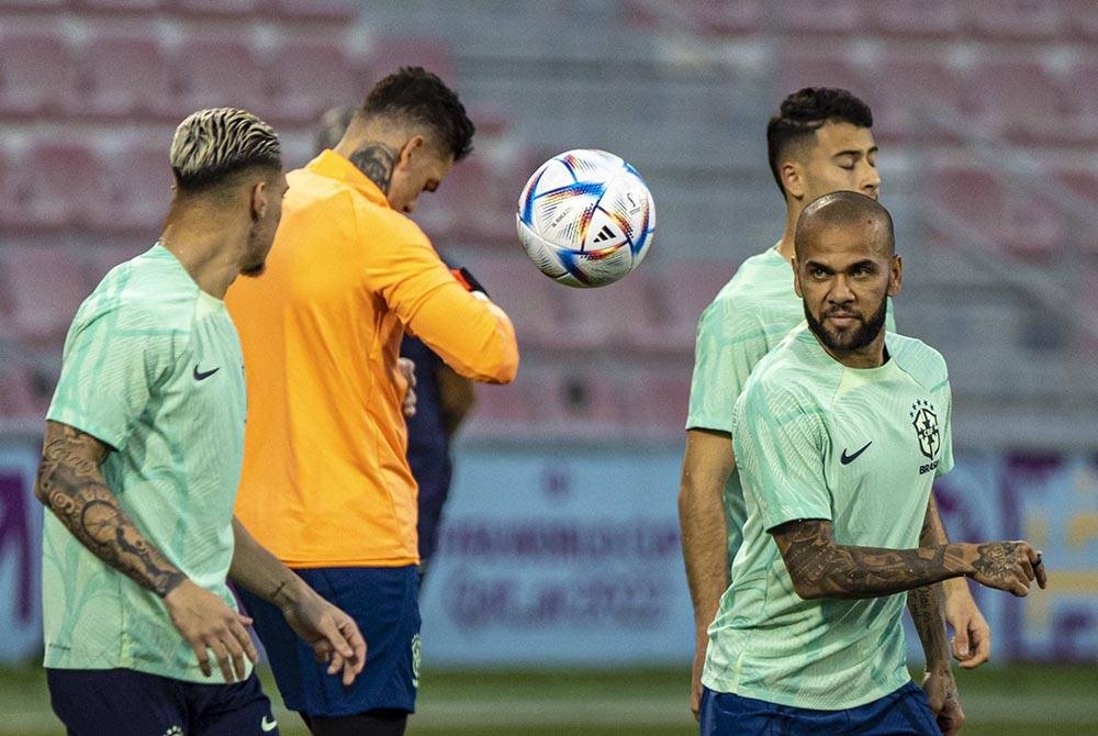 Alves (kanan) beraksi semasa sesi latihan pasukan bola sepak kebangsaan Brazil di Doha, Qatar pada Ahad. - Foto EPA