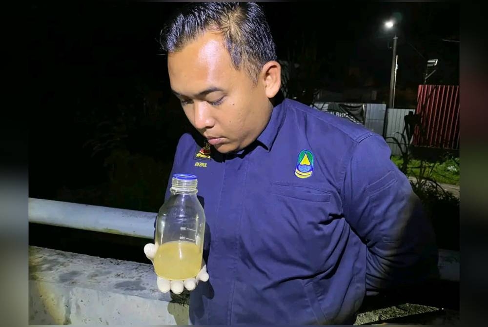 Salah seorang kakitangan LUAS mencium sampel air bagi mengesan pencemaran bau di Kampung Rinching Hilir di Sungai Semenyih pada Khamis.