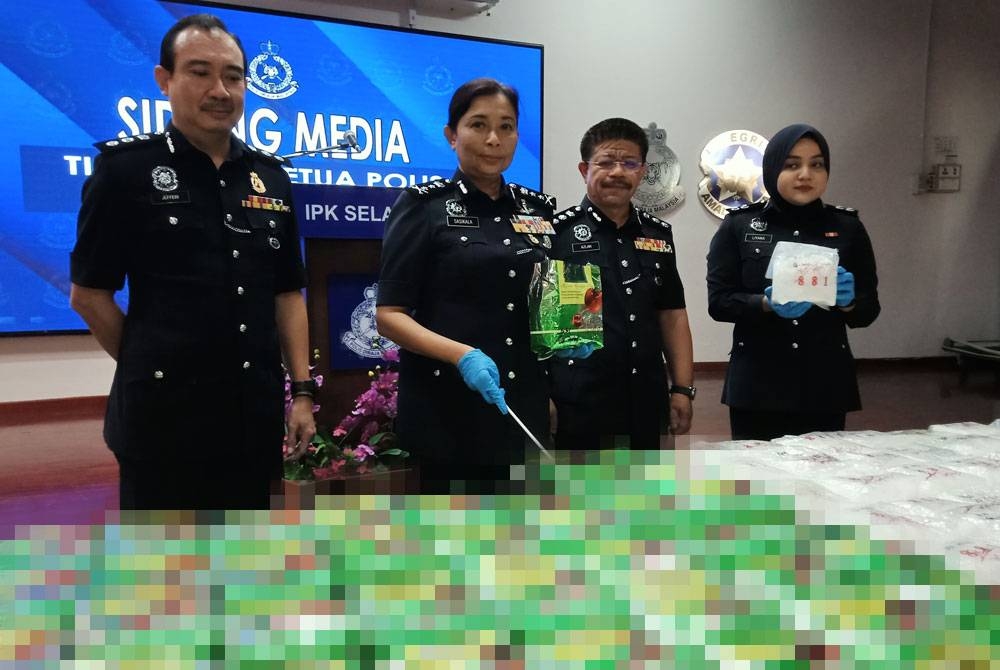 Sasikala (dua dari kiri) menunjukkan bungkusan teh Cina mengandungi dadah jenis methapatamine yang dirampas menerusi serbuan di sebuah rumah di Bandar Sunway, Subang Jaya pada Rabu.