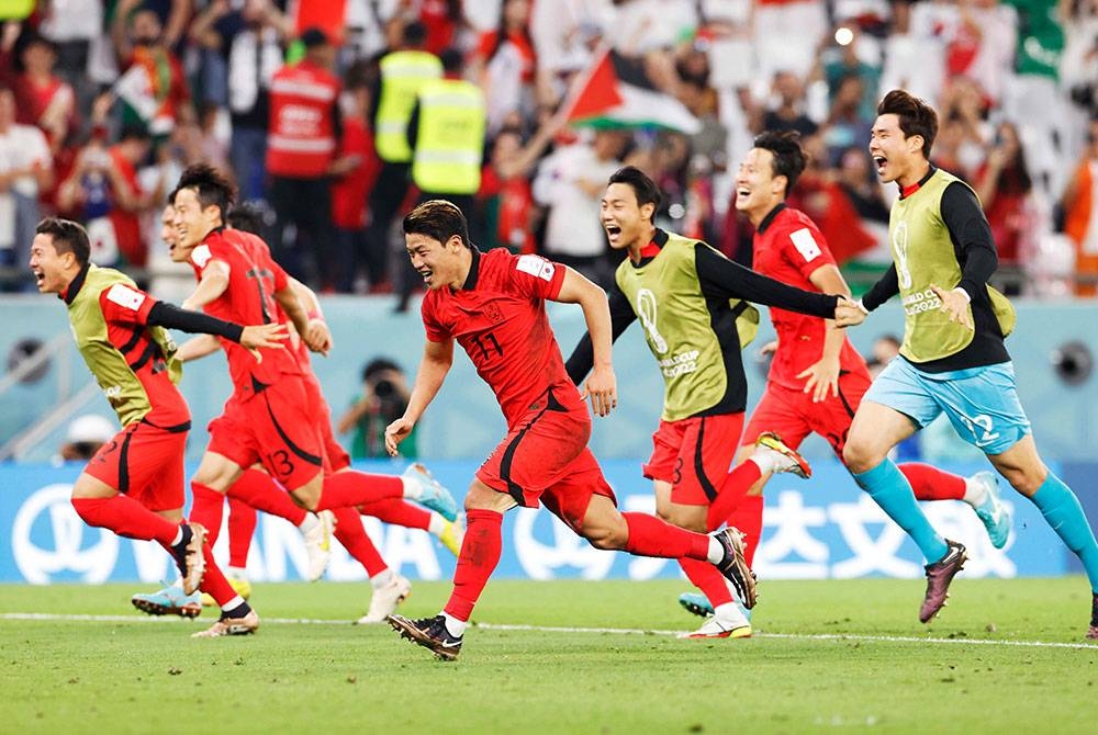 Hee-chan (tengah) penjaring gol kedua Korea Selatan meraikan jaringan bersama pemain lain ketika perlawanan Kumpulan H Piala Dunia Qatar 2022 menentang Portugal di Stadium Education City, Doha. - Foto EPA