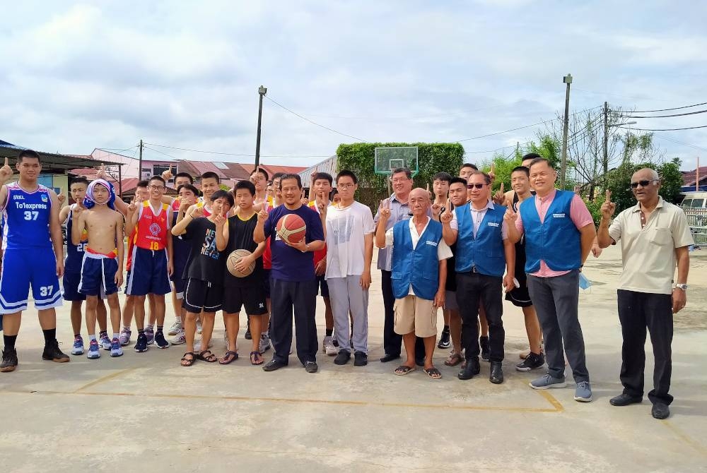 Azman (depan; tengah) ditemui media ketika berkempen di gelanggang bola keranjang di pekan Lunas, Kulim pada Sabtu.