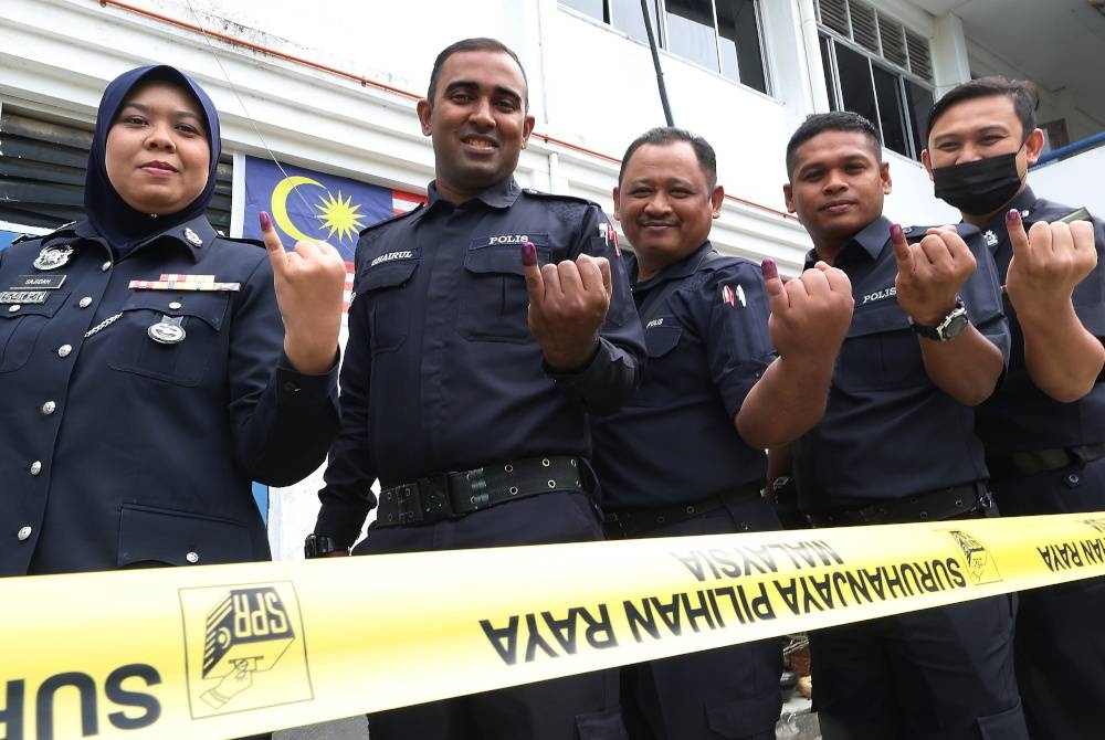 Anggota Polis Ibu Pejabat Polis Daerah Kulim menunjukkan jari yang sudah dicelup dakwat kekal pada hari mengundi awal sempena PRU15 bagi Parlimen P.017 Padang Serai pada Sabtu. - Foto Bernama