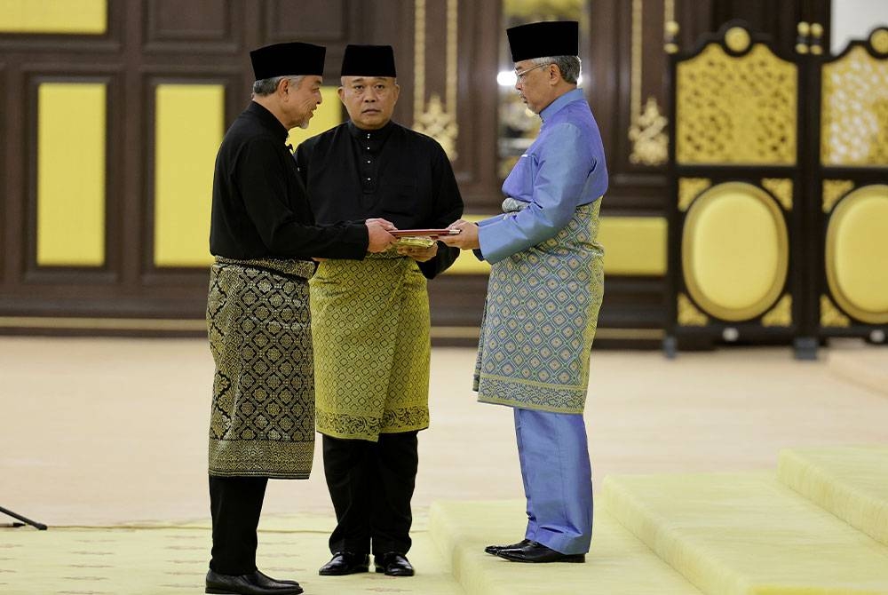 Yang di-Pertuan Agong berkenan mengurniakan surat cara pelantikan jawatan sebagai Timbalan Perdana Menteri kepada Ahmad Zahid di Istana Negara pada Sabtu.- Foto Bernama