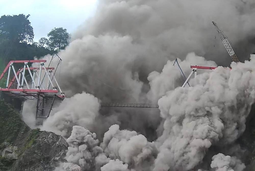 Awan panas menyelubungi jambatan Glada Perak yang menghubungkan perkampungan di sekitar Lumajang. - Foto AFP