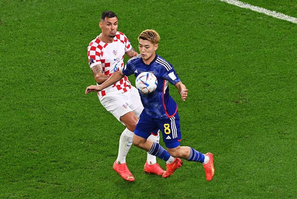 Ritsu (kanan) cuba melepasi kawalan pemain Croatia pada aksi kalah mati Piala Dunia Qatar 2022 pada Selasa. - Foto EPA