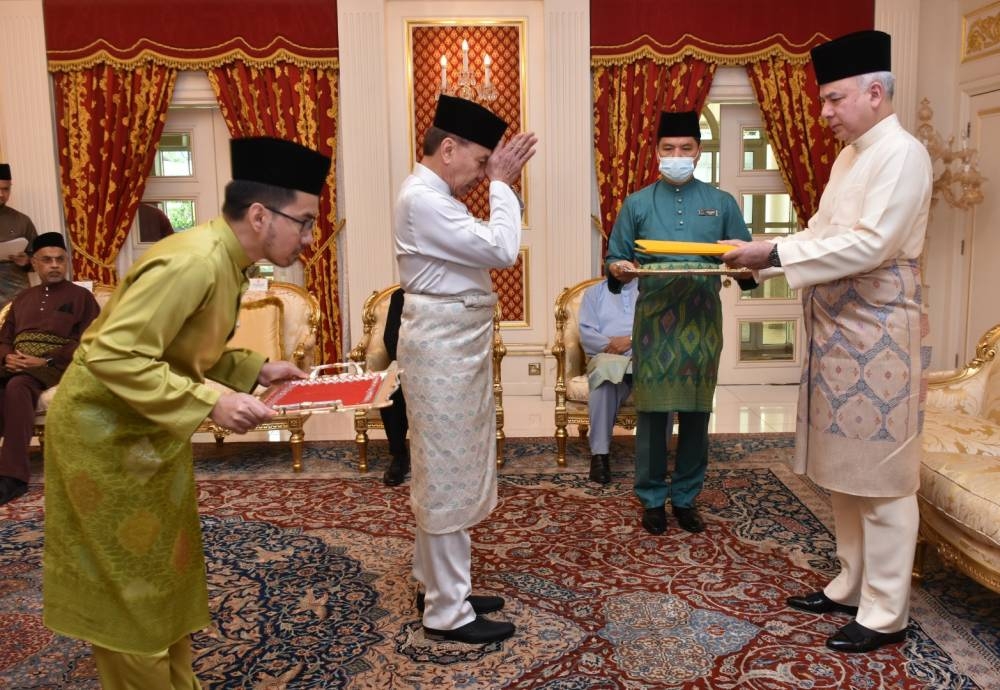 Sultan Nazrin (kanan) menyerahkan bayaran zakat perniagaan dan pendapatan berjumlah RM2.98 juta kepada Mohd Annuar selepas majlis berkenaan di Istana Changkat Persekutuan di sini pada Selasa.