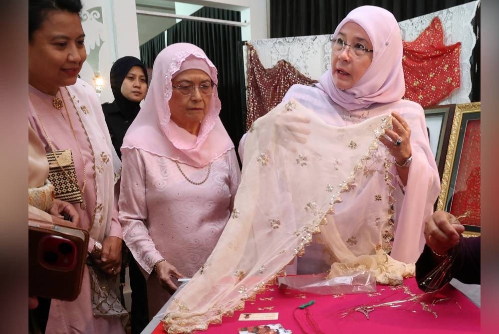 Raja Permaisuri Agong, Tunku Hajah Azizah Aminah Maimunah Iskandariah berkenan menghadiahkan keringkam perkahwinan miliknya untuk dipamerkan di Muzium Sarawak selepas merasmikan Lembaran Emas Siri 2: Borneo Textile Symposium, pada Selasa. - Foto Bernama