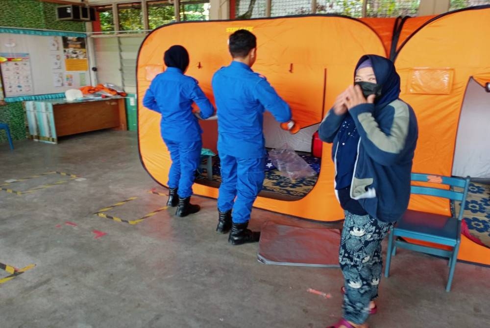 Anggota APM membantu menyediakan keperluan untuk mangsa banjir di salah satu PPS yang dibuka di negeri ini pada Rabu.