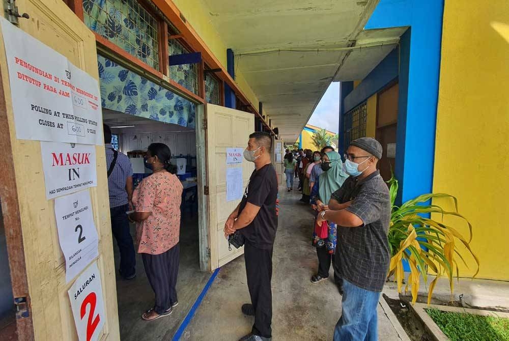 Pengundi dilihat sedang berbaris menunggu giliran sebelum proses pembuangan undi di Sekolah Kebangsaan Bukit Selarong, Padang Serai, Kedah pada Rabu.