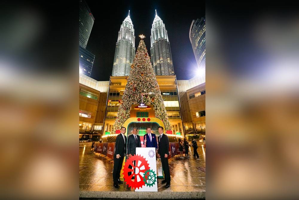 Andrew (dua dari kanan) berdiri di hadapan pokok krismas ikonik setinggi 30 meter di The Esplanade, Suria KLCC.