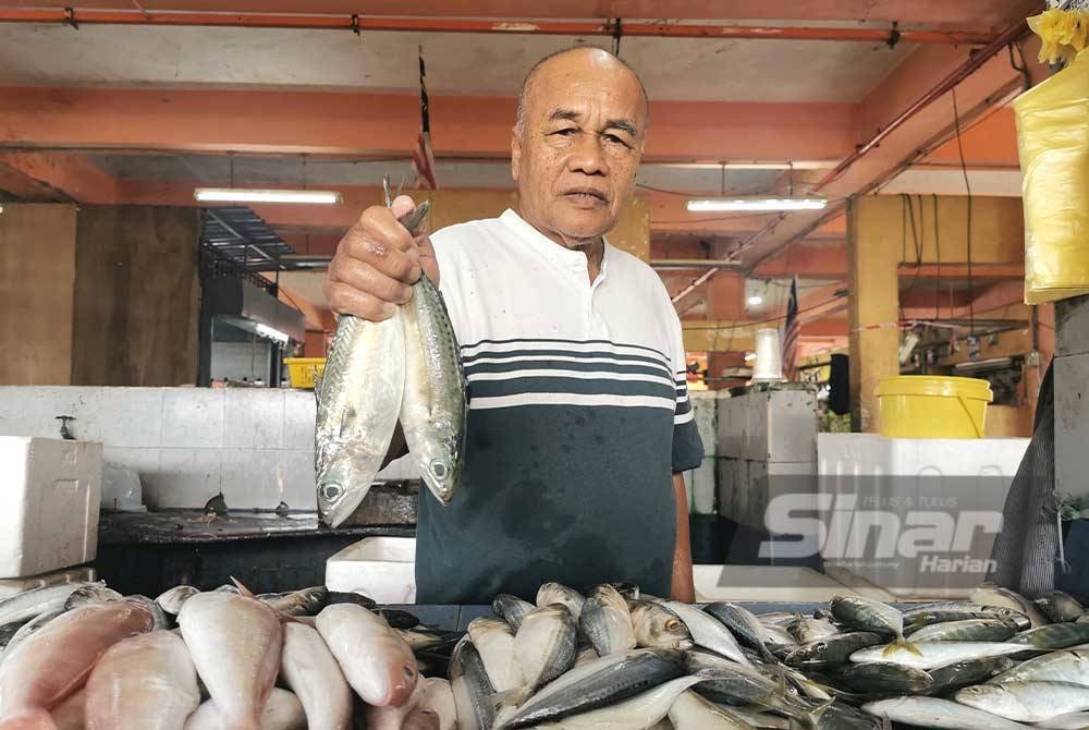 Zaki menunjukkan ikan kembung segar yang dijual di Pasar Bukit Besar di Kuala Terengganu.