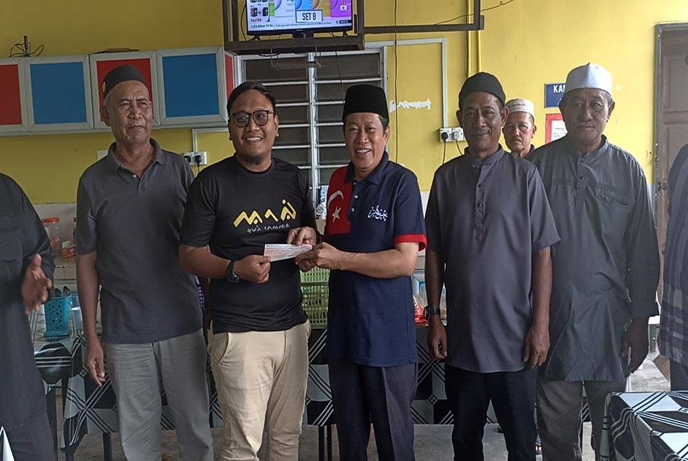 Ahmad (tiga dari kanan) menyerahkan sumbangan kepada belia Kampung Jawa Ulu pada Jumaat.