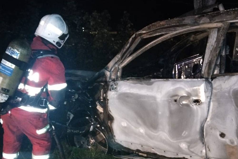 Anggota bomba melakukan pemadaman kereta jenis Chevrolet yang terbakar di lokasi kejadian. Foto: Bomba Perak