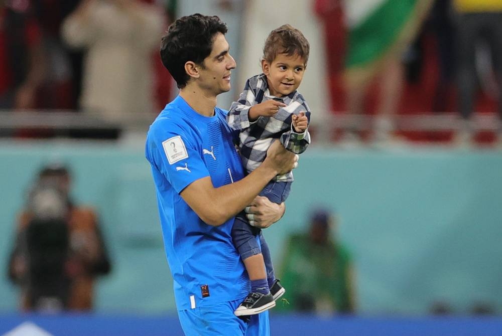 Bounou bersama anaknya, Isaac selepas membantu Maghribi mara ke separuh akhir Piala Dunia setelah menewaskan Portugal 1-0 di Stadium Al Thumama pada Ahad. - Foto EPA