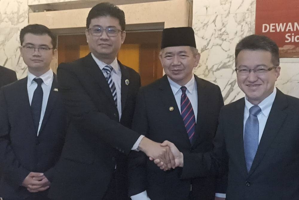 Andrew Chen (kiri) bersalaman dengan Chin Tong (kanan) selepas sidang akhbar pengumuman Ketua Pembangkang DUN Johor yang baharu oleh Salahuddin di Kota Iskanda, pada Ahad.