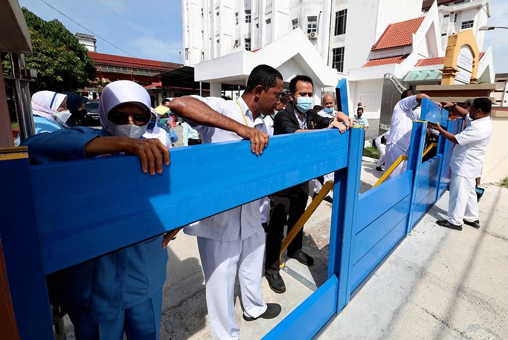 Sebahagian petugas HRPZ II melakukan latihan amali memasang penghadang banjir bagi mencegah kejadian banjir besar luar jangka seperti bah kuning pada Disember 2014 yang pernah melanda hospital tersebut. - Foto Bernama