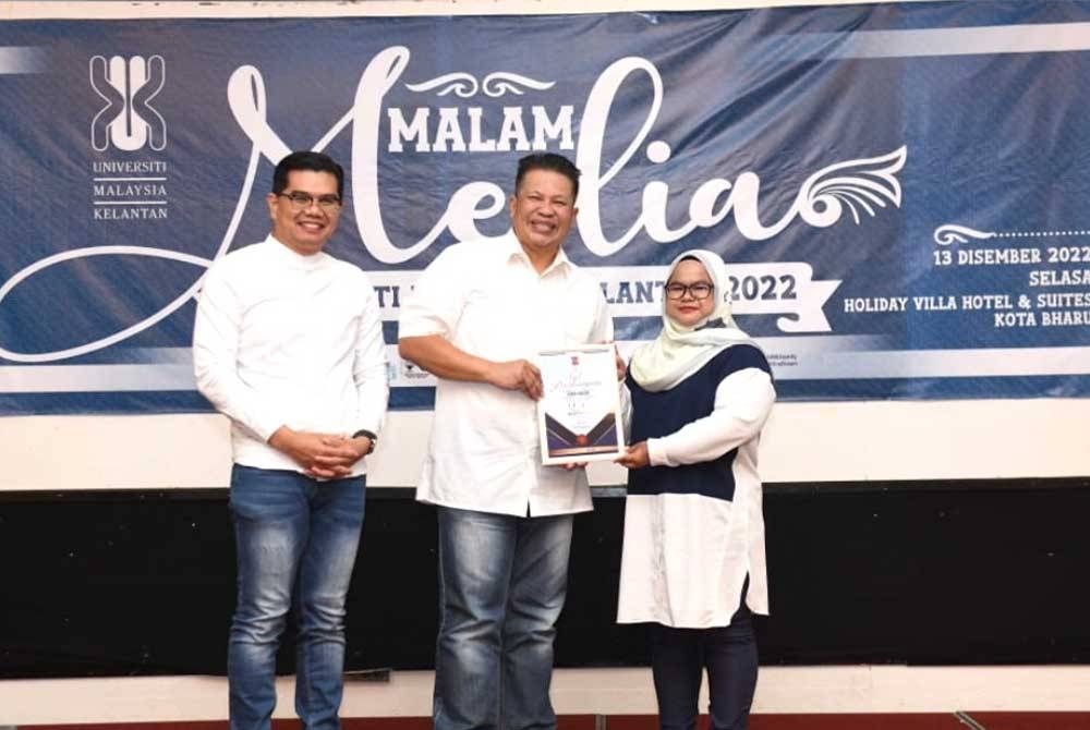 Dr Razli (tengah) menyampaikan anugerah kepada Hazelen Liana (kanan).