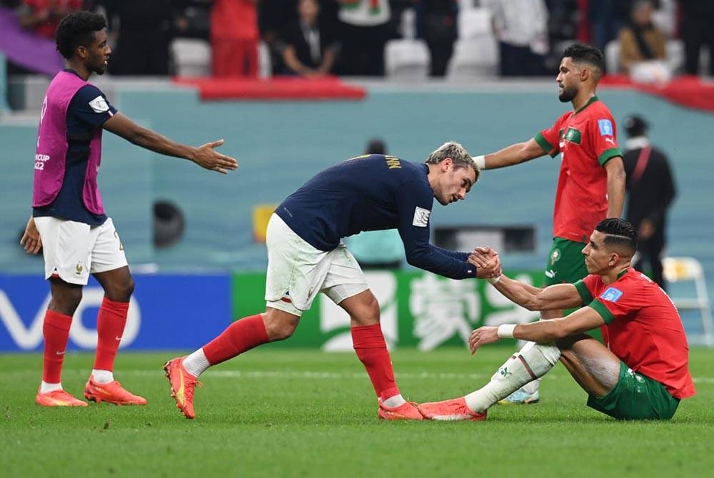 Griezmann (tengah) bersalam dengan pemain Maghribi, Jawad El Yamiq selepas aksi separuh akhir Piala Dunia Qatar di Stadium Al Bayt pada Khamis. - Foto EPA