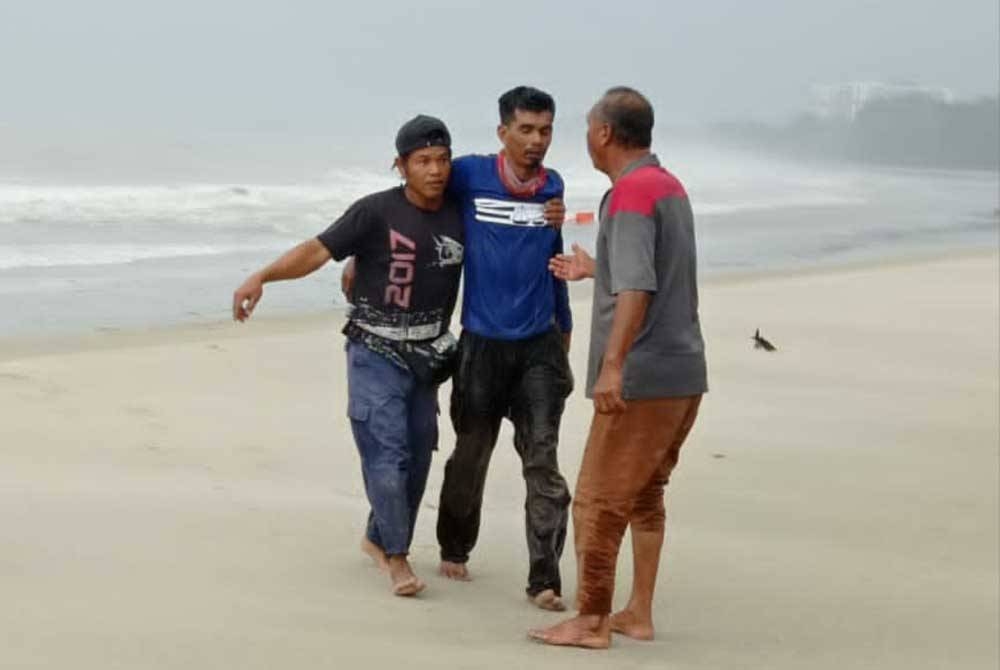 Syed Shahrizam (tengah) ketika diselamatkan selepas lebih sejam terapung di laut pada Selasa.