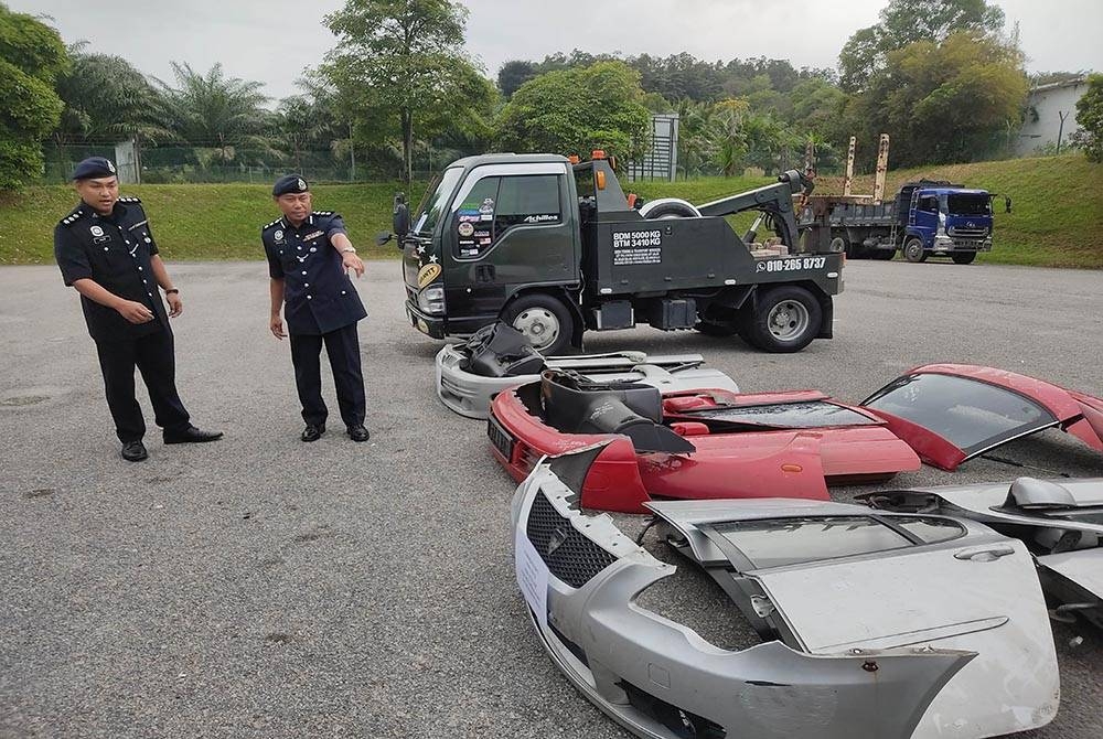 Wan Kamarul Azran (kanan) menunjukkan komponen kenderaan curi yang dirampas susulan penahanan empat suspek di sekitar Lembah Klang, baru-baru ini.